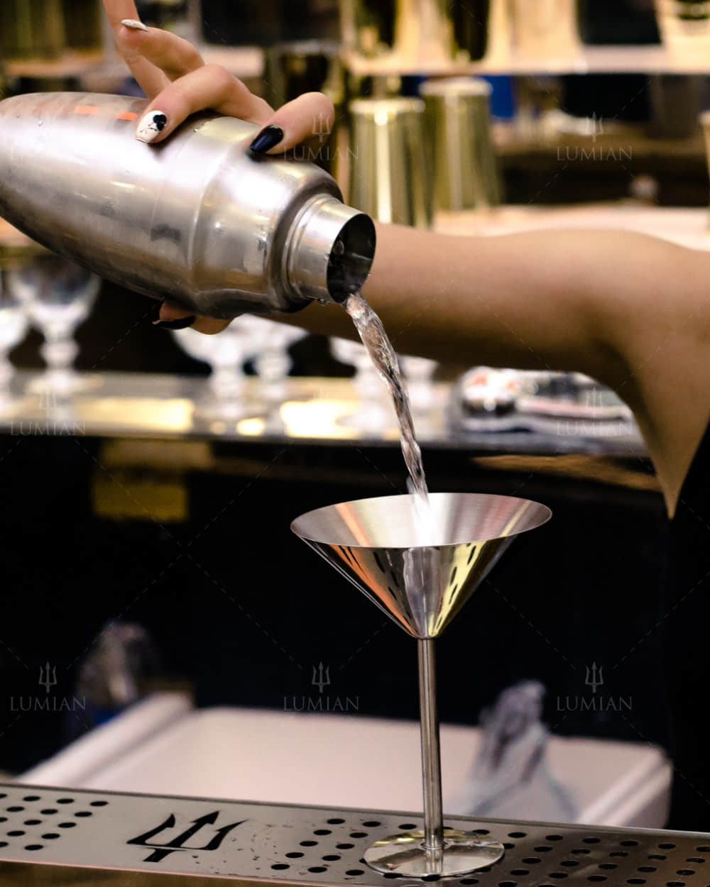 Cocktail mit dreiteiligem Cocktailshaker in Silber eingießen