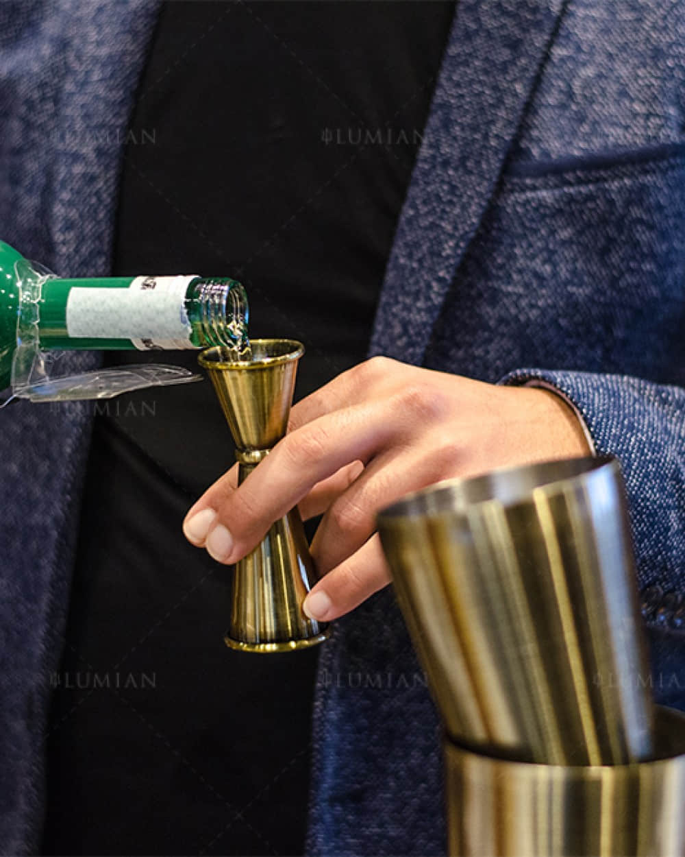 Cocktail mit japanischem Barmaß in Bronze abmessen