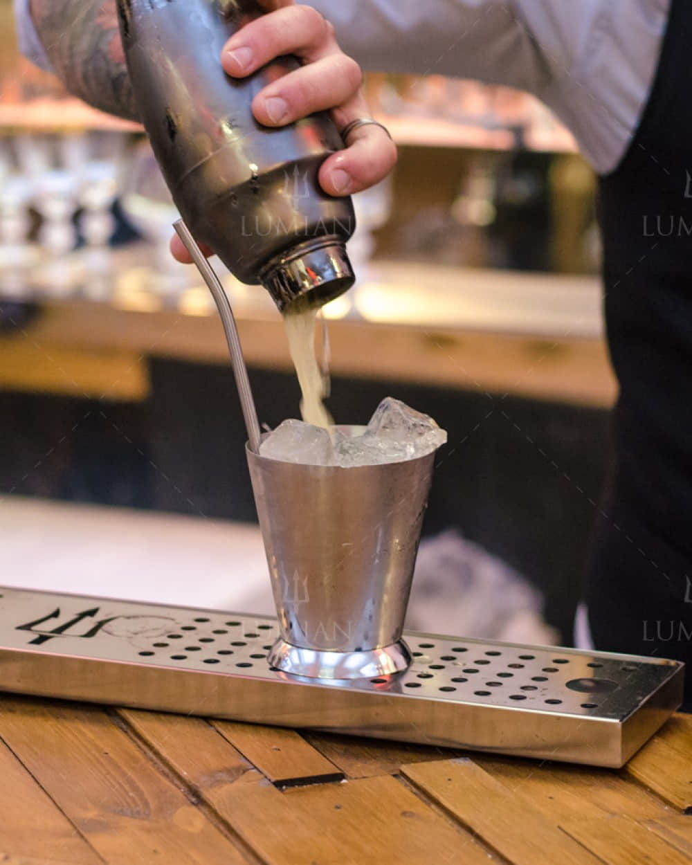 Cocktail mit dreiteiligem Cocktailshaker in Schwarz eingießen