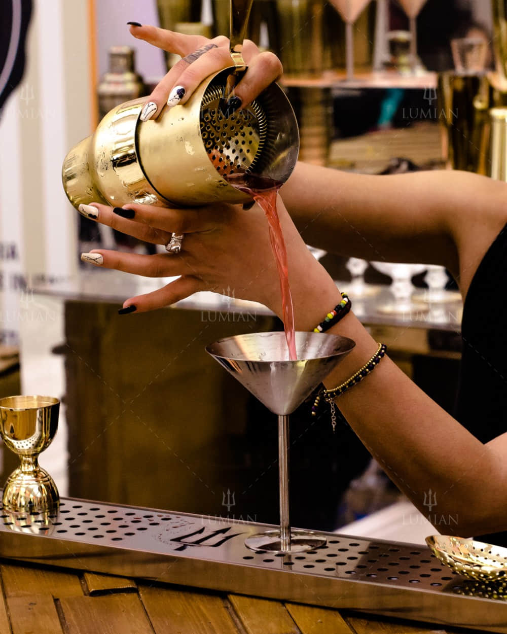 Goldener Parisian Cocktailshaker gießt Cocktail ein