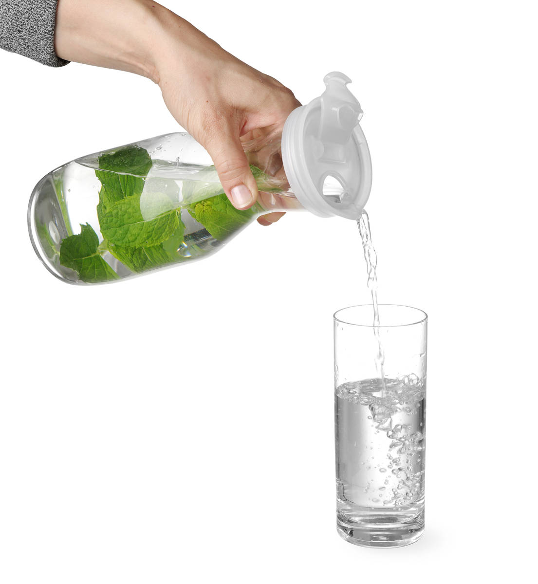 Hand beim Eingießen eines Glases mit Wasserkaraffe