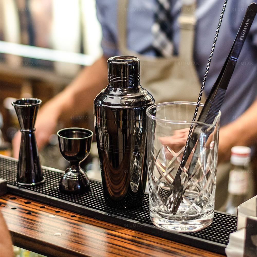 Dreiteiliger Cocktailshaker mit Barzubehör auf Theke Dreiteilige Cocktailshaker auf Cocktailbar