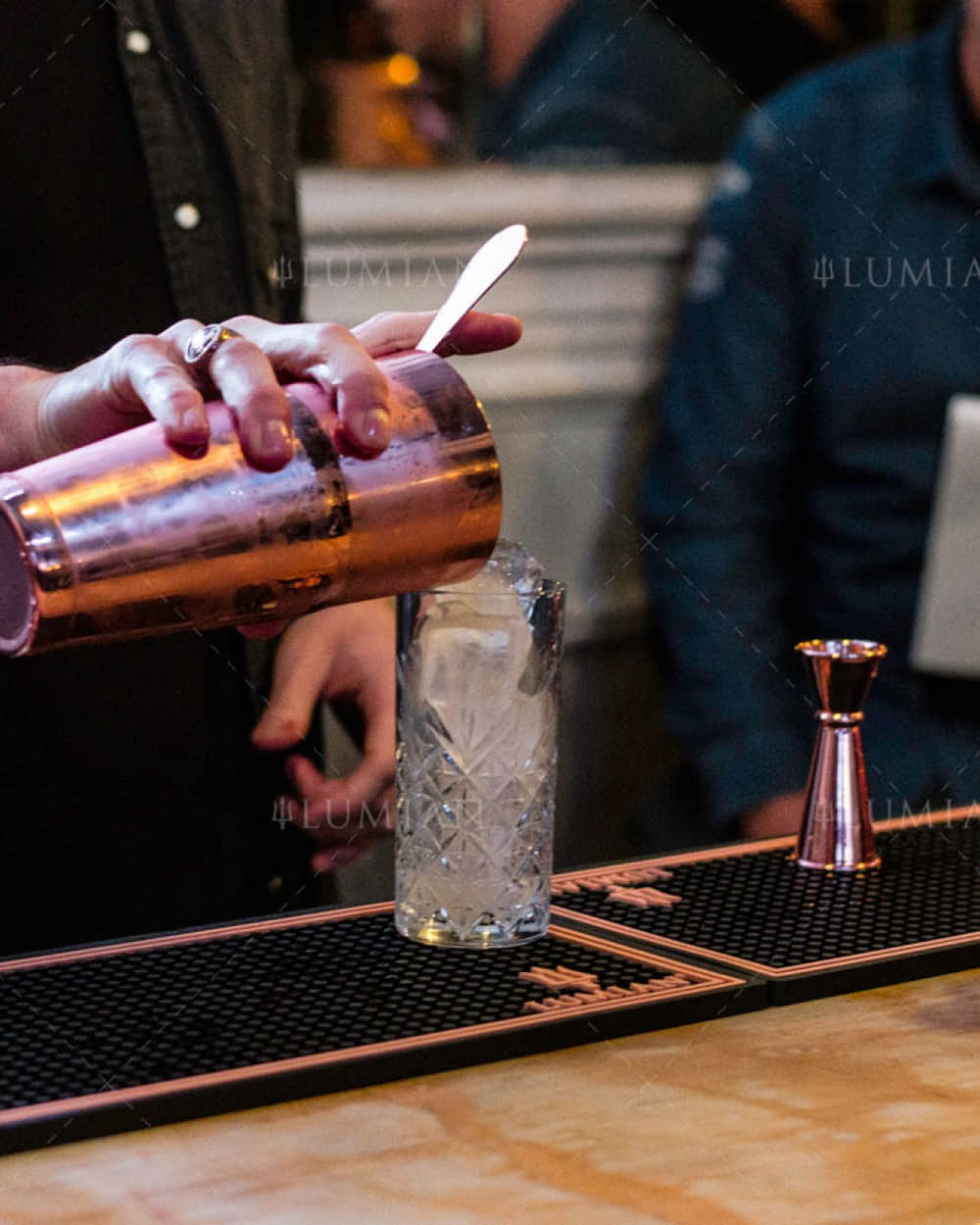 Kupferner Tin in Tin Cocktailshaker gießt Cocktail ein