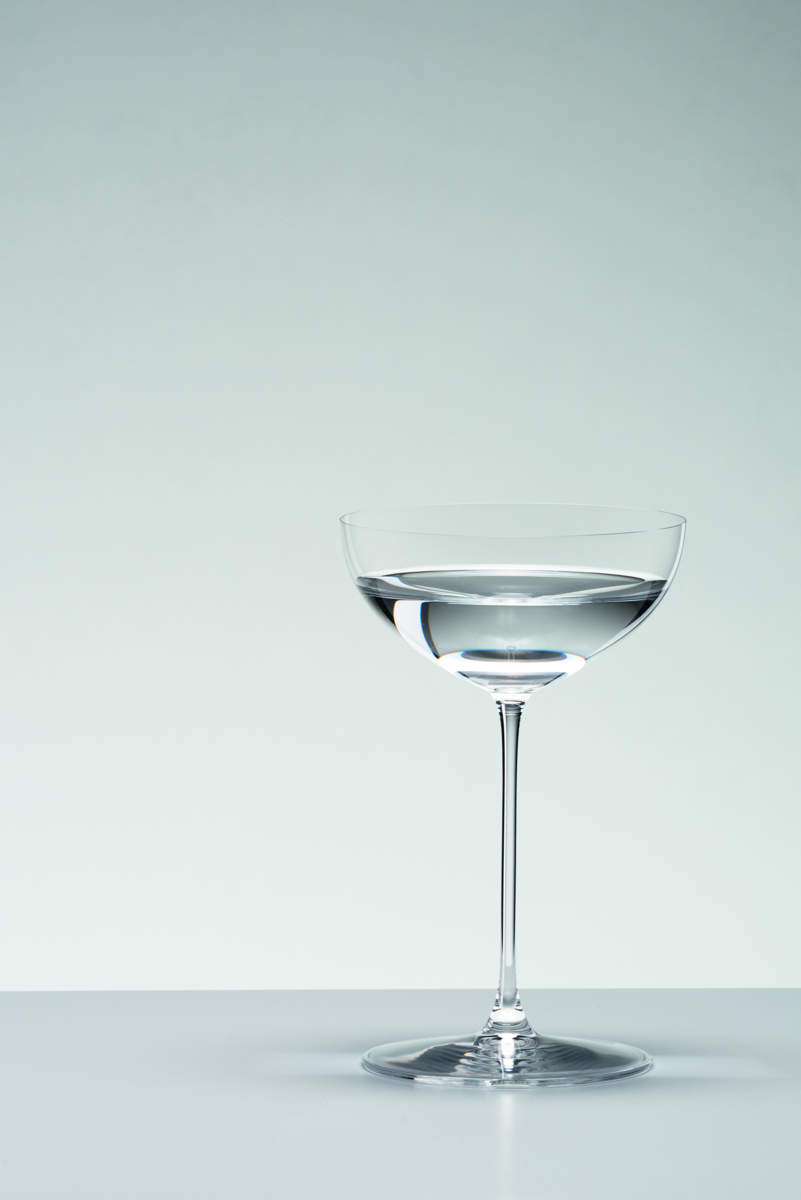 Mit Martini gefüllte Riedel Glas Veritas Coupe Cocktailschale vor grauem Hintergrund