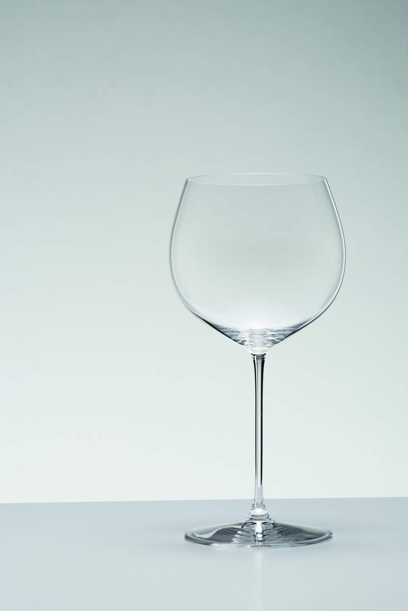 Riedel Glas Veritas Chardonnay Eichenfass Weinglas grau Veritas Weißweinglas Chardonnay im Eichenfass gereift von Riedel Glas vor grauem Hintergrund