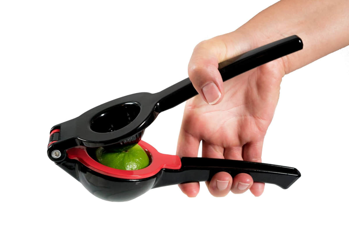 Schwarze Handsaftpresse drückt Limette aus