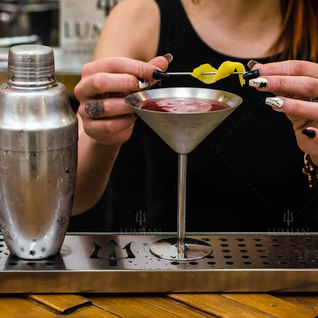 Silberner Cocktailshaker neben Martiniglas