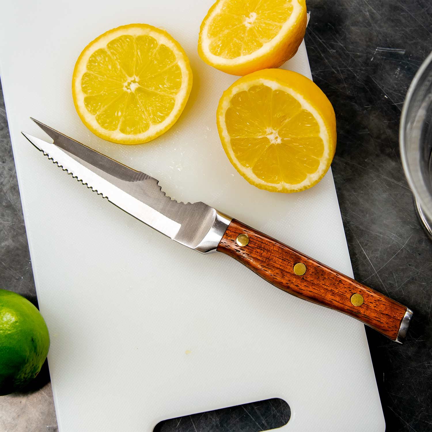 Messer für Cocktailzutaten neben Zitronenscheiben