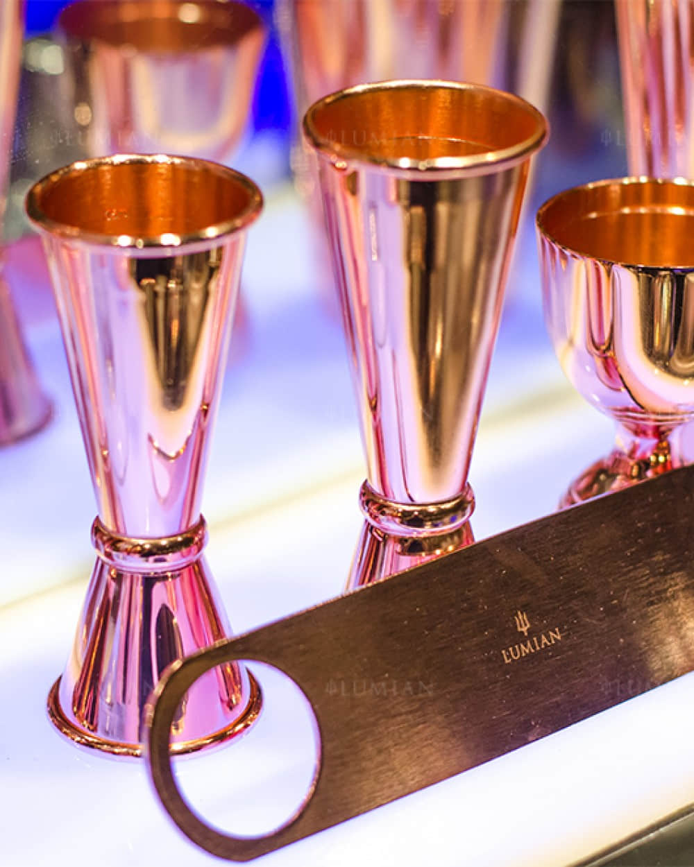 Kupferner Flaschenöffner vor Cocktail Jiggern