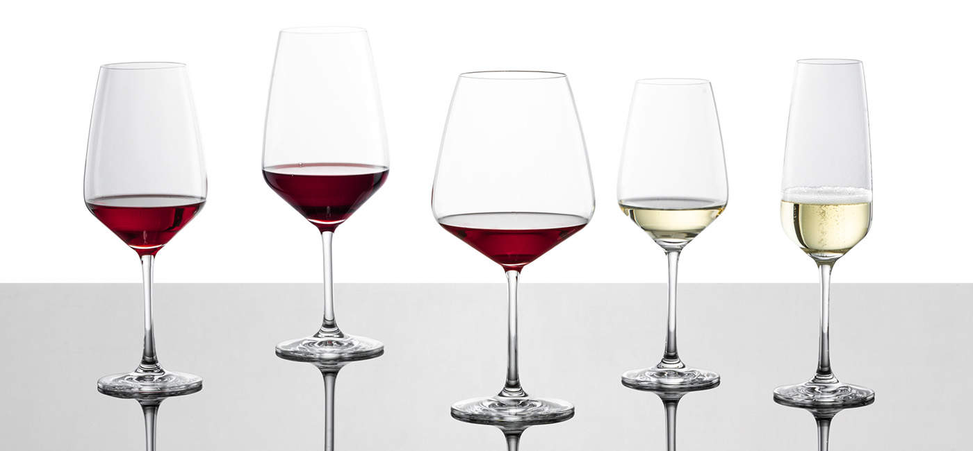 Fünf gefüllte Wein- und Sektgläser Taste von Schott Zwiesel stehen auf einer Glasplatte