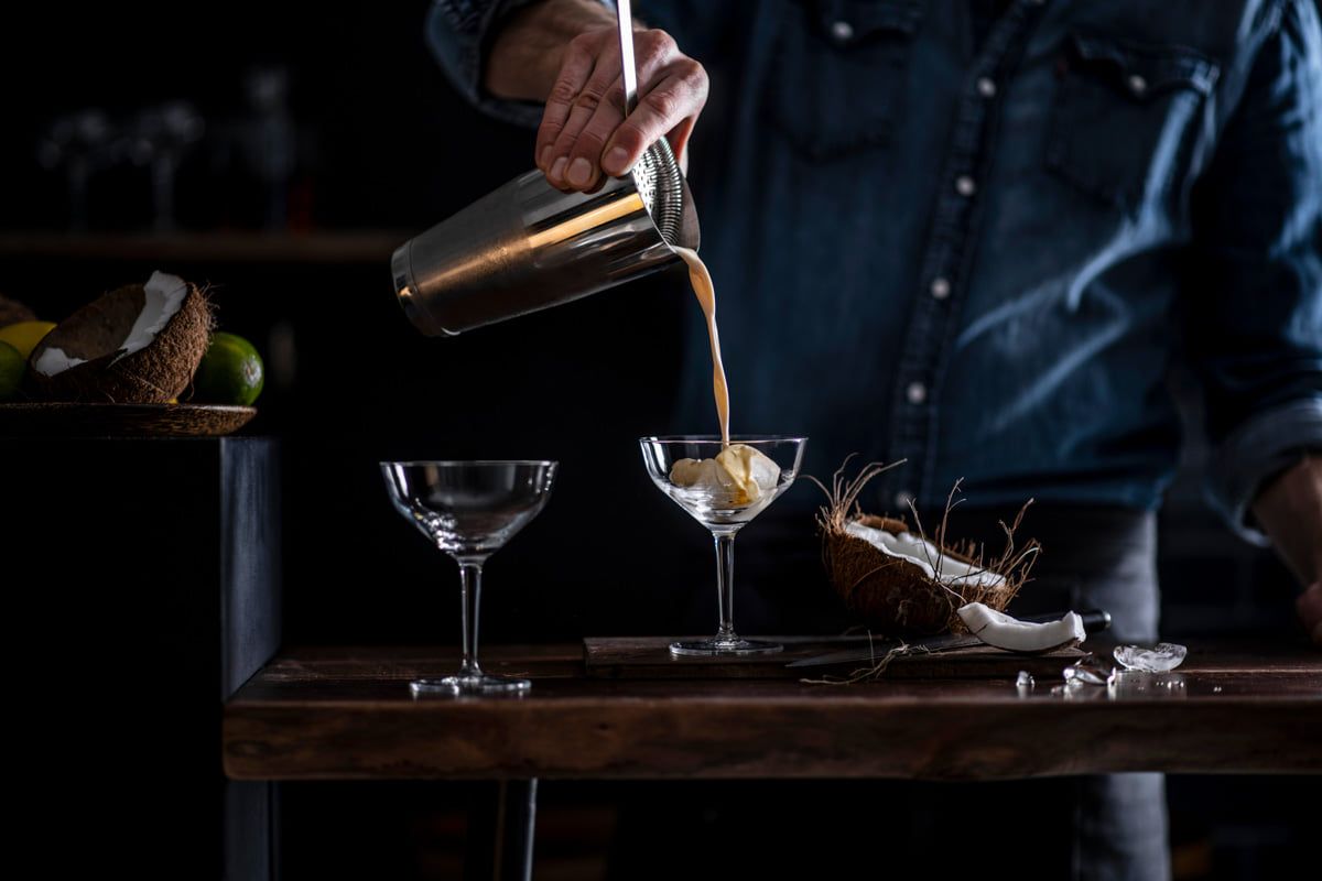 Drinks anrichten in Gläsern der Basic Bar Selection von Schott Zwiesel Barman beim Eingießen eines Drinks
