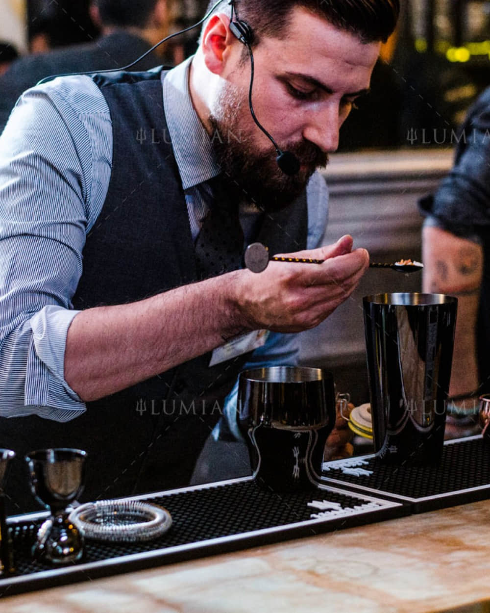 Cocktailzutaten mit schwarzem Barlöffel abmessen