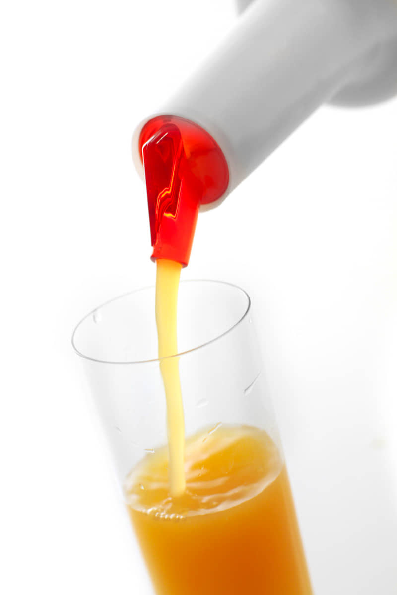 Orangensaft aus Speedbottle in Glas eingießen